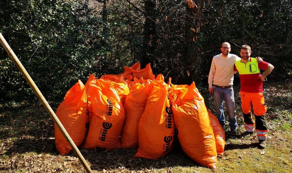 The picture represent multiple orange plastic bags filled with leaves at the end of our gardening work.